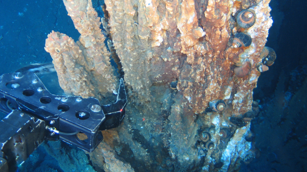 A robotic arm breaks off a chunk of mineral-rich rock deep underwater. Nautilus Minerals of Australia hopes to develop and expand undersea mining by extracting copper, gold, silver and zinc from the seafloor.