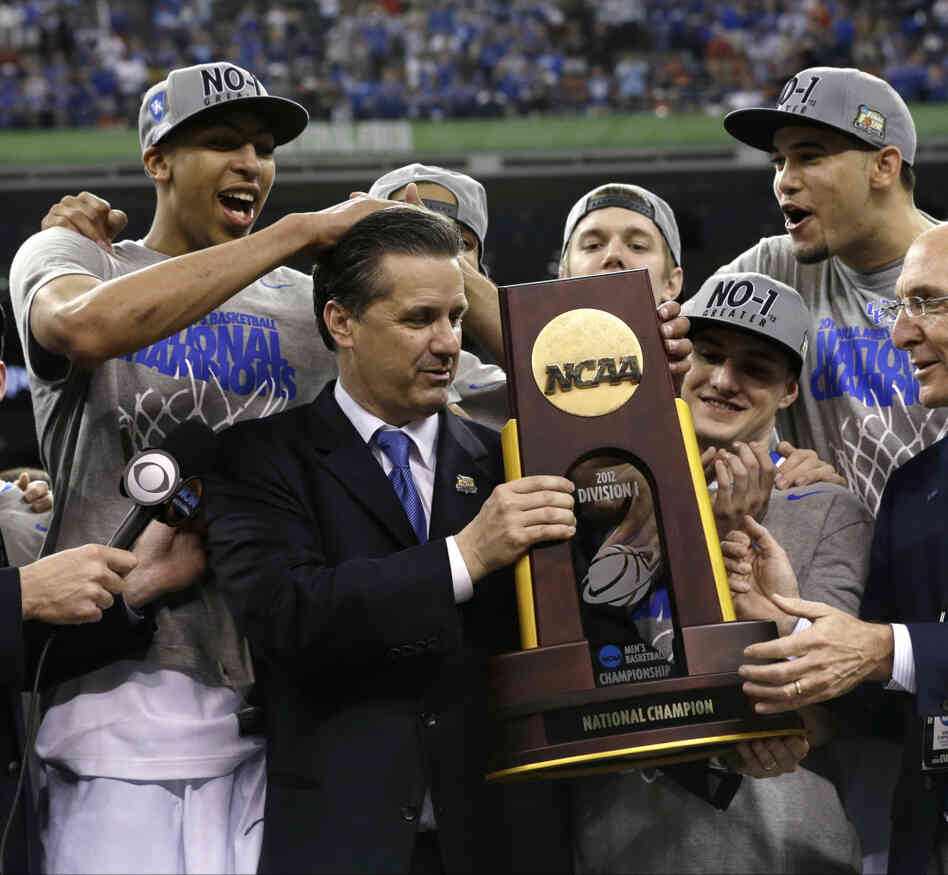 Kentucky head coach John Calipari (center) celebrates with his team after the Wildcats beat the University of Kansas on Monday to clinch the title.