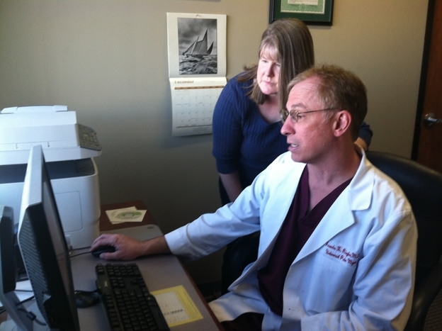 At Universal Pain Management, Dr. Francis Riegler confers with Trudy Roberts, the clinic's nurse practitioner, over a patient's record of prescription drug purchases.