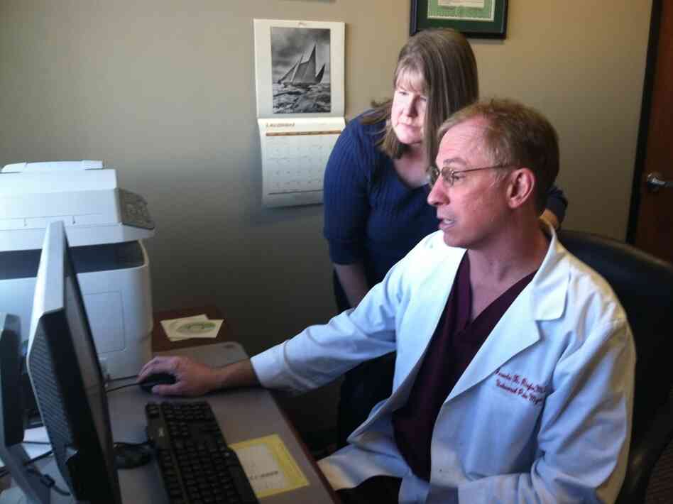 At Universal Pain Management, Dr. Francis Riegler confers with Trudy Roberts, the clinic's nurse practitioner, over a patient's record of prescription drug purchases.