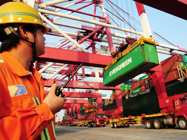 A worker monitors the loading of containers on to a ship at a harbor in China's Shandong province. Under a new U.S. law, Chinese food exporters will now have to share more food safety information with American food importers.