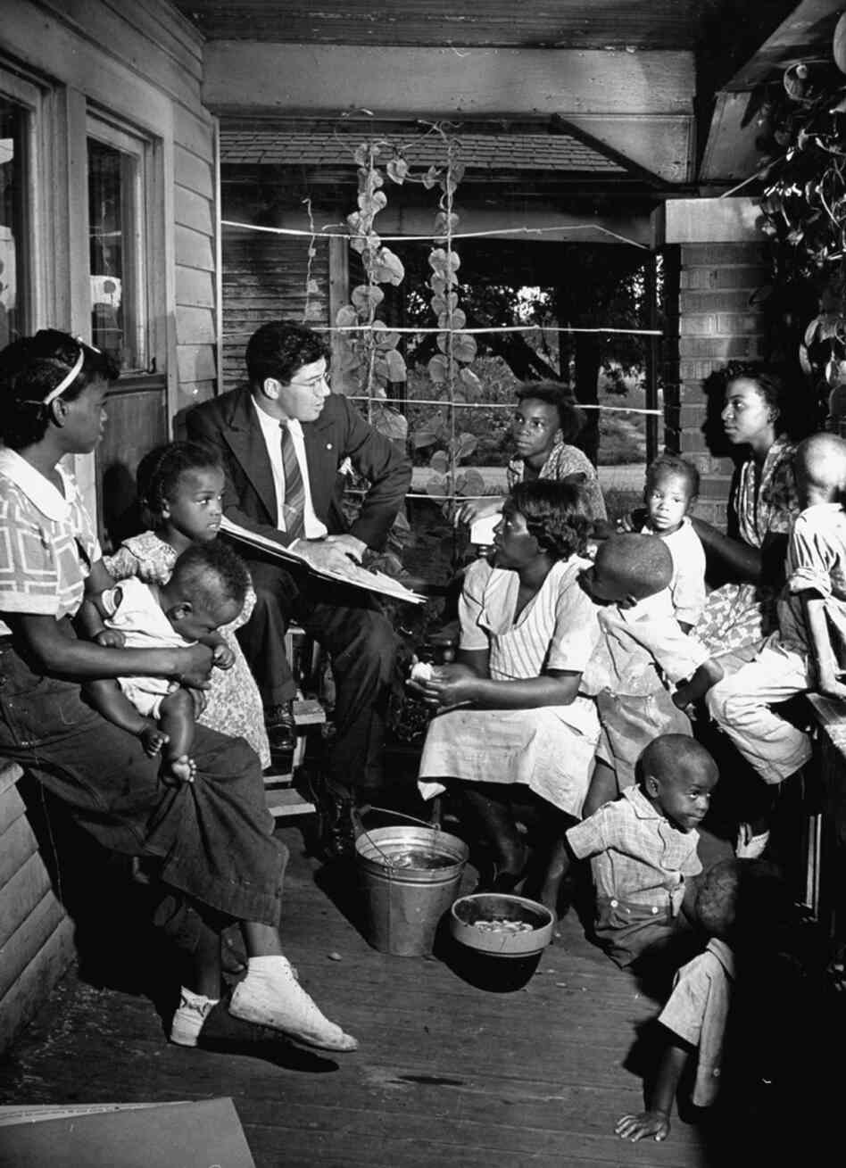 Census taker Seymour Weiss (fourth from left) questions Mrs. George B. Townsend (center) in Indiana, 1939. Census taker Seymour Weiss (fourth from left) questions Mrs. George B. Townsend (center) in Indiana, 1939.