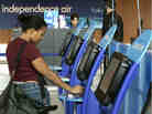 Lauren Goss of Knoxville, Tennessee, uses a self check-in machine to issue her boarding pass in front of an Independence Air ticketing counter at Dulles International Airport May 2, 2005 in Centreville, Virgina. In our second hour, Marketplace special correspondent David Brancaccio talks about his series, Robots Ate My Job, and how technology is becoming a bigger part of our lives.