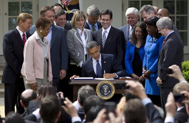 President Barack Obama signs the Jumpstart our Business Startups (JOBS) Act, on Thursday in the Rose Garden of the White House in Washington.