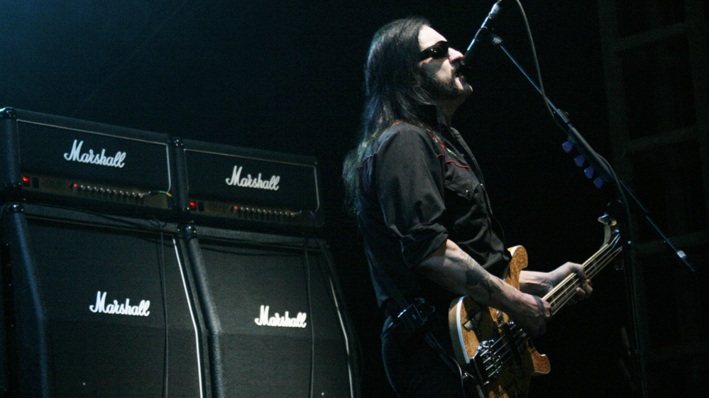 Lemmy Kilmister of Motorhead in front of a line of Marshall amps.