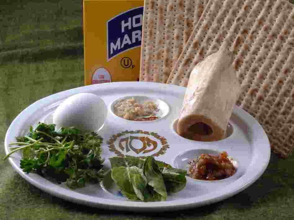The Passover Seder plate with symbolic foods (clockwise, from top center): horseradish; a shank bone; a mixture of fruit, wine and nuts called haroset; lettuce, parsley and an egg. 