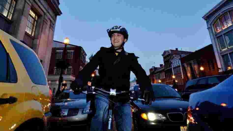 A cyclist rides in heavy traffic in downtown Washington, D.C.