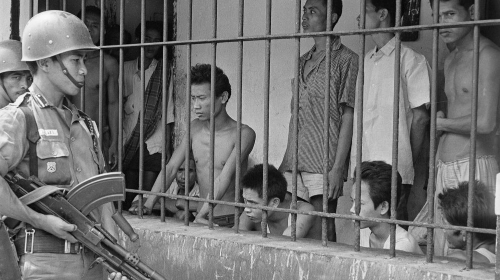 A coup attempt in Indonesia on Sept. 30, 1965, triggered a series of events that led to the ouster of President Sukarno and unleashed a wave of violence against suspected communists in the country that left up to 1 million people dead. In this photo from 1965, Indonesian soldiers watch suspected communists held at Tangerang, a suburb of Jakarta, the Indonesian capital. 