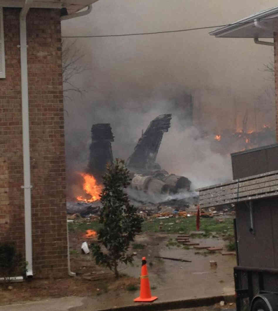The burning fuselage of an F/A-18 Hornet lies smoldering after crashing into a residential building in Virginia Beach, Va. on Friday.