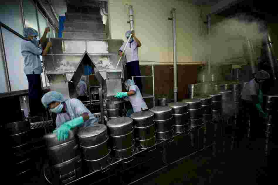 Rice falls down a chute (top left) and is packed into sterilized stainless steel vessels for delivery to schools. Over time, Akshaya Patra has learned what children like in different regions and has customized the kitchen according to the local palate.