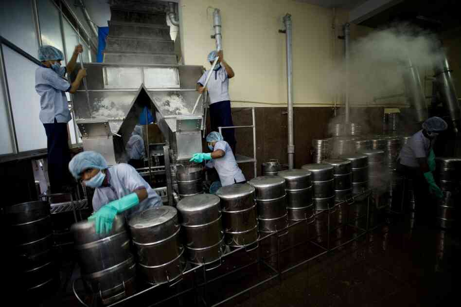 Rice falls down a chute (top left) and is packed into sterilized stainless steel vessels for delivery to schools. Over time, Akshaya Patra has learned what children like in different regions and has customized the kitchen according to the local palate.