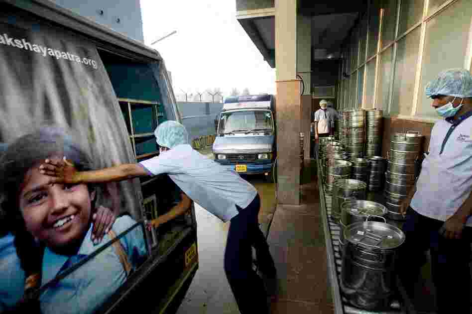 A workman closes the door of an Akshaya Patra truck filled with fresh school lunches. Some 34 trucks head out from this kitchen every school day, providing lunch for nearly 150,000 children in the Bangalore area.