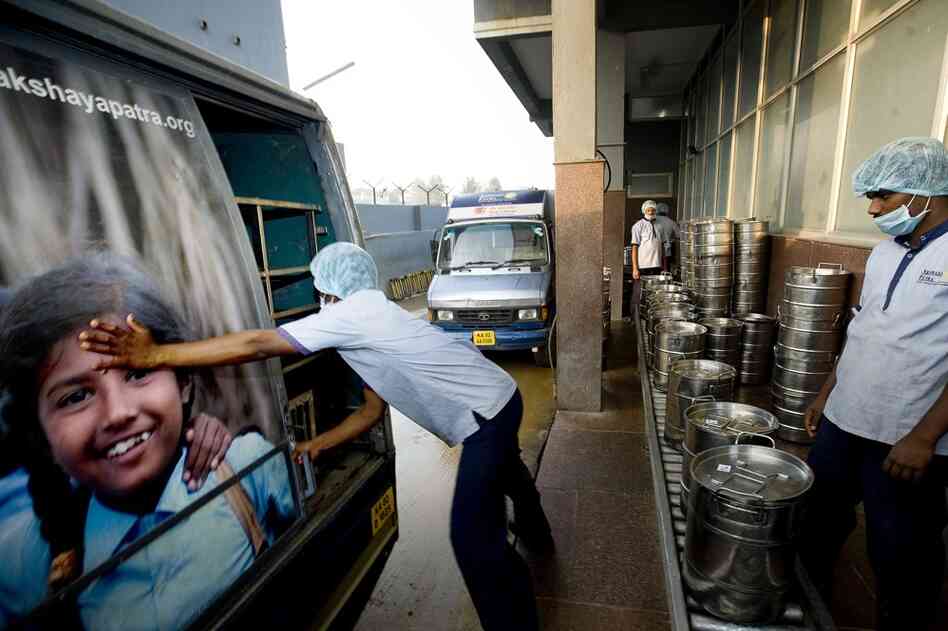 A workman closes the door of an Akshaya Patra truck filled with fresh school lunches. Some 34 trucks head out from this kitchen every school day, providing lunch for nearly 150,000 children in the Bangalore area.