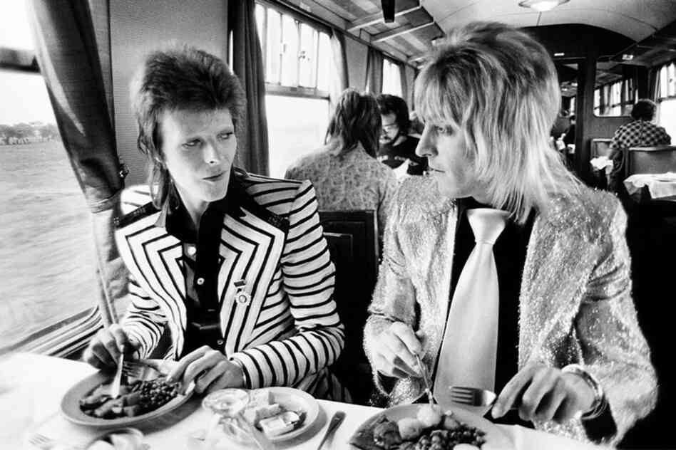 David Bowie and Mick Ronson at lunch on a train to Aberdeen, 1973