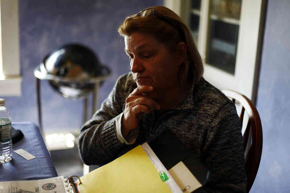 Judy Nestico flips through a binder containing John's military paperwork. Nestico was involved in an IED attack during his deployment and sought out additional psychological help upon his return.
