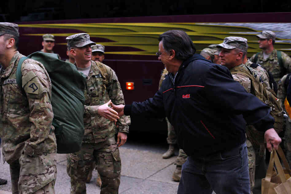 Frank Nestico Sr. welcomes John home with a handshake shortly after he stepped off the bus.