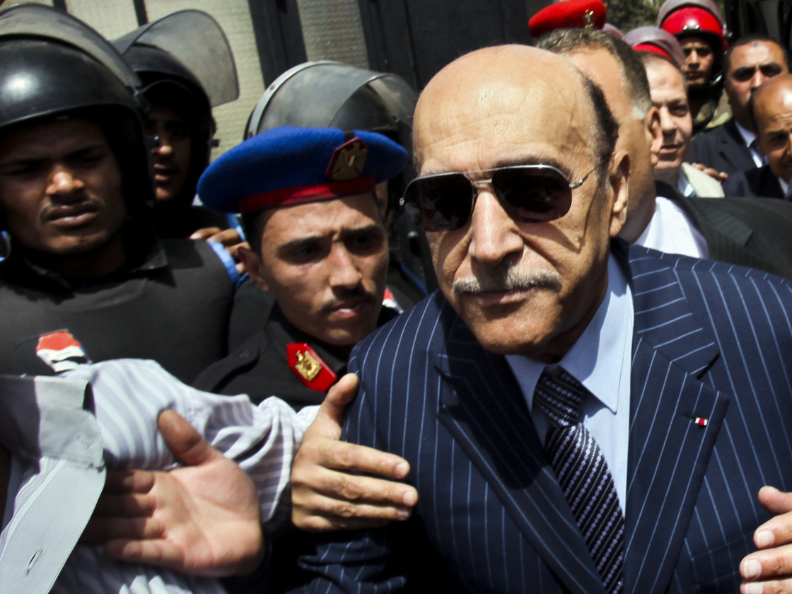 Omar Suleiman (right), who was intelligence chief and vice president under former Egyptian President Hosni Mubarak, leaves the presidential elections committee headquarters in Cairo on April 7, after submitting his candidacy papers. 