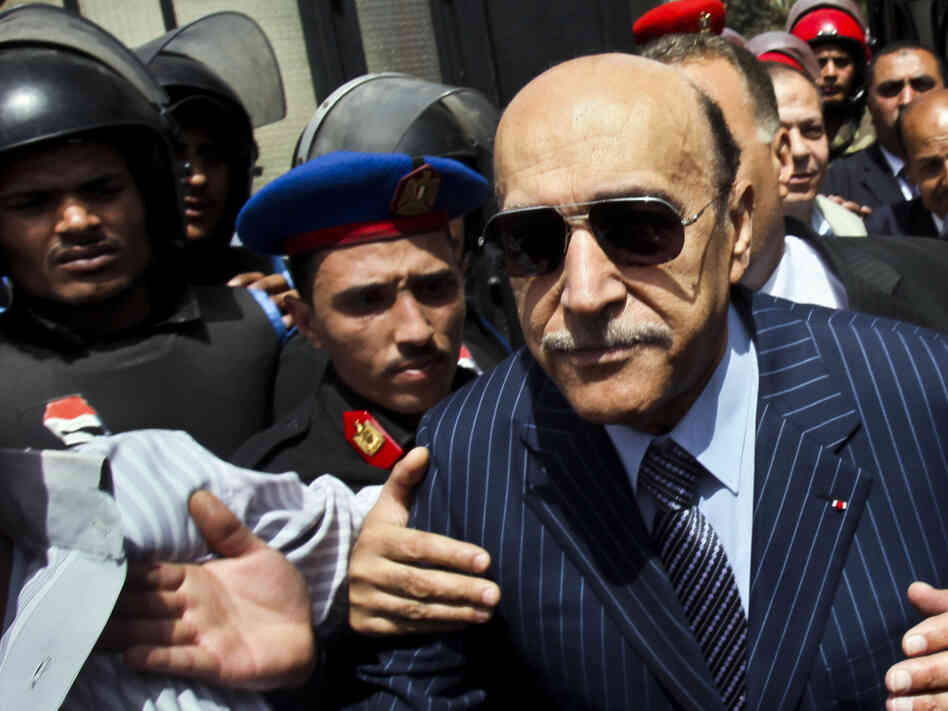 Omar Suleiman (right), who was intelligence chief and vice president under former Egyptian President Hosni Mubarak, leaves the presidential elections committee headquarters in Cairo on April 7, after submitting his candidacy papers. 