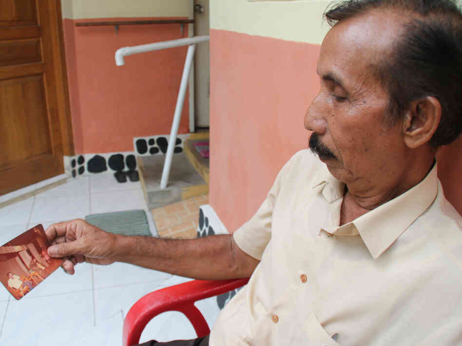 Former law student and teacher Tumiso Nitikarjita Lukas looks at pictures of his days in exile on a remote Indonesian island during the 1970s. Before being exiled, he was arrested and tortured on suspicion of being a communist, which he has steadfastly denied.