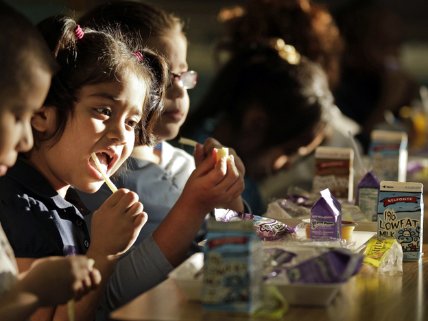 Students at Garfield Elementary School eat dinner as part of an after-school program in Kansas City, Mo. In the past few years, a federally subsidized school dinner program has spread from six to all 50 states.