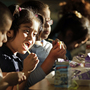 Students at Garfield Elementary School eat dinner as part of an after-school program in Kansas City, Mo. In the past few years, a federally subsidized school dinner program has spread from six to all 50 states.