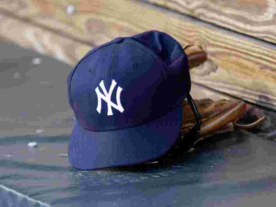 A New York Yankees hat and glove rest in the dugout before a game at Oriole Park at Camden Yards.