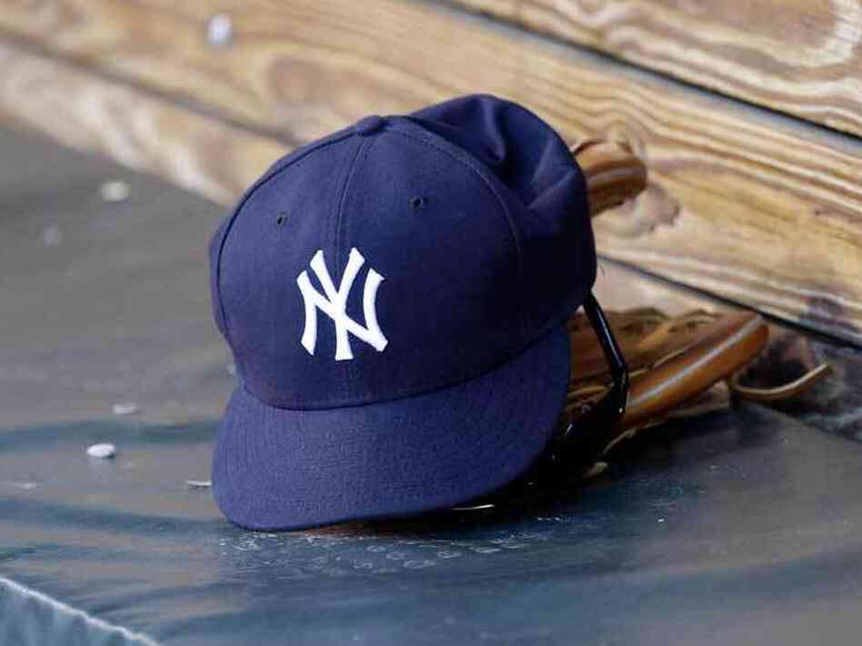 A New York Yankees hat and glove rest in the dugout before a game at Oriole Park at Camden Yards.