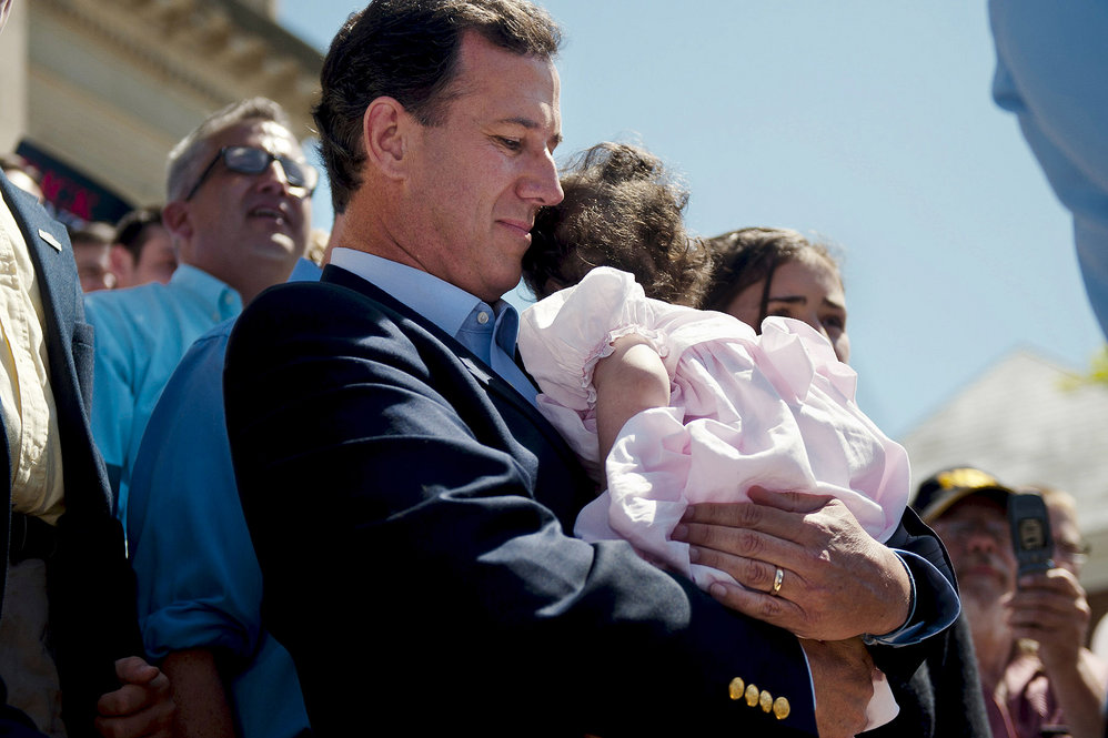 Santorum, shown holding his youngest child, Bella, who has a rare genetic disease, left the trail twice when she was hospitalized. 