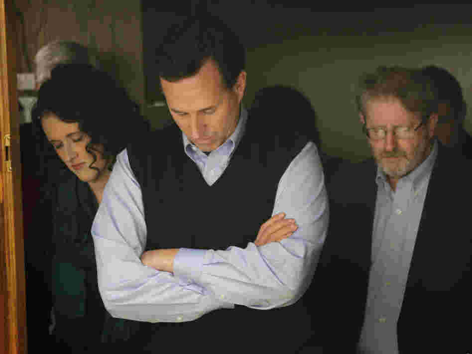 Santorum bows his head in prayer during a campaign rally in the basement of the Northwestern Bank building in Orange City, Iowa, on Jan. 1.