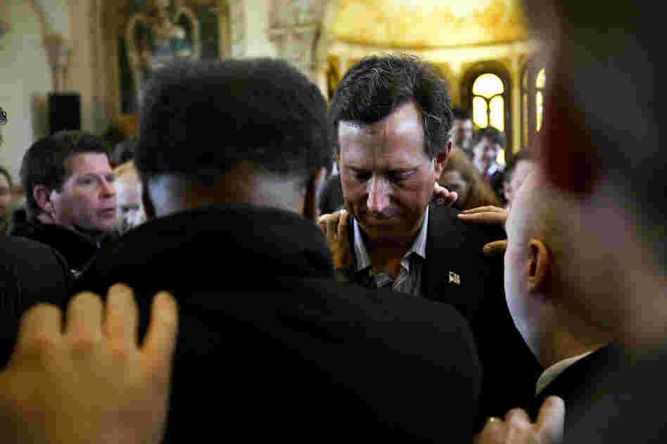 A day after Santorum's Feb. 7 victories in Colorado, Minnesota and Missouri, supporters in McKinney, Texas, pray over him. 