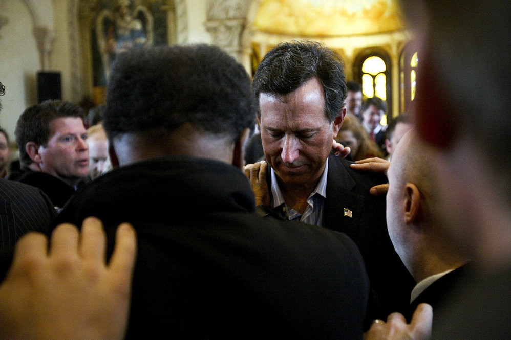 A day after Santorum's Feb. 7 victories in Colorado, Minnesota and Missouri, supporters in McKinney, Texas, pray over him. 