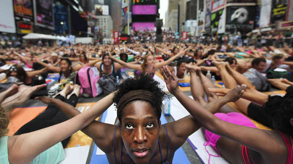 Bernice Acosta and other yoga enthusiasts practice in New York's Times Square at an event marking the 2011 summer solstice. Some Hindus say such events have little to do with yoga's spiritual roots. Bernice Acosta and other yoga enthusiasts practice in New York's Times Square at an event marking the 2011 summer solstice. Some Hindus say such events have little to do with yoga's spiritual roots.