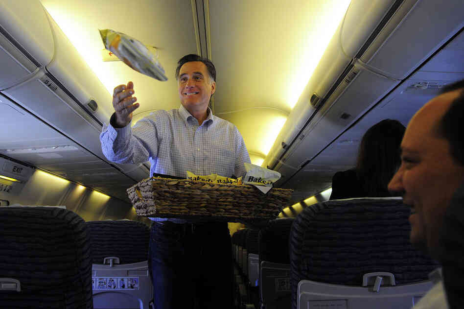 Peanuts! Popcorn!: Mitt Romney throws snacks to journalists on his campaign plane in Jacksonville, Fla., in January. 