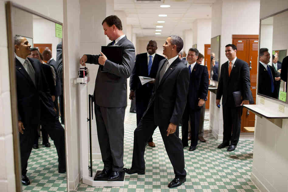 Tripped Up: Obama puts his toe on the scale as Trip Director Marvin Nicholson weighs himself at a University of Texas locker room in 2010. 