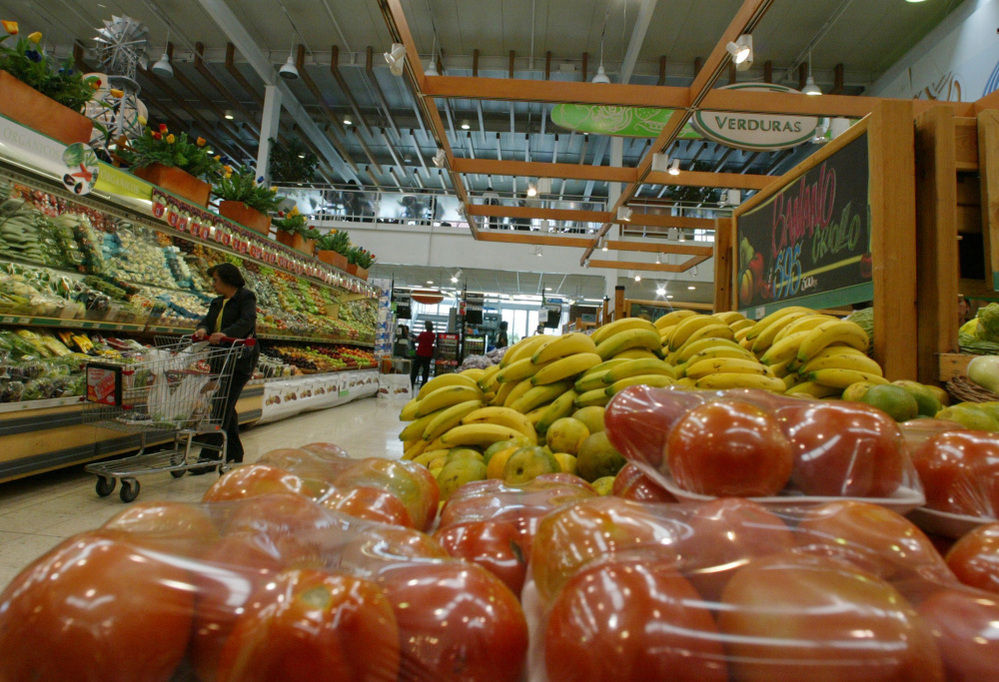  A woman looks over vegetables in Carulla Supermarket in Bogota, Colombia. The country, which plays host this weekend to the Summit of the Americas, is a rising star in the region. Foreign investment has quadrupled over the past decade, and it has a new free-trade agreement with the U.S.
