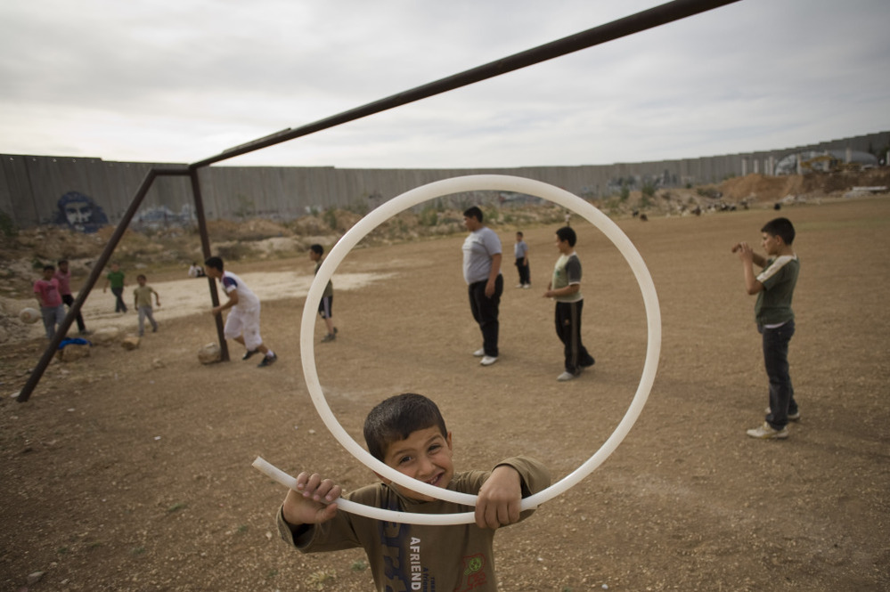 Palestinian children play next to Israel's separation barrier in the West Bank town of Abu Dis in 2011. As peace talks between Israel and Palestine remain at a standstill, people are looking to other possible solutions.