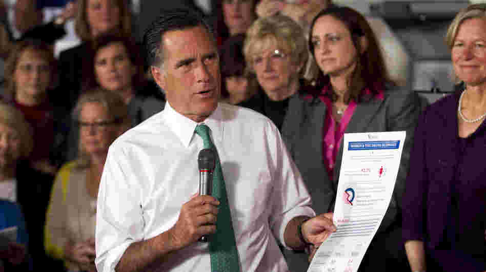 Mitt Romney holds a flier titled "Women & The Obama Economy" as he speaks in Hartford, Conn., Wednesday