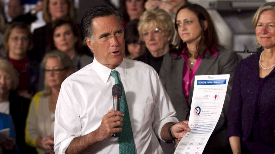 Mitt Romney holds a flier titled "Women & The Obama Economy" as he speaks in Hartford, Conn., Wednesday