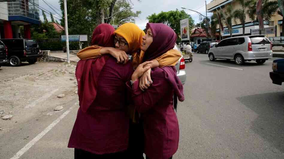 Acehnese women hug each other shortly after the powerful  earthquake hit the western coast of Sumatra in Banda Aceh.