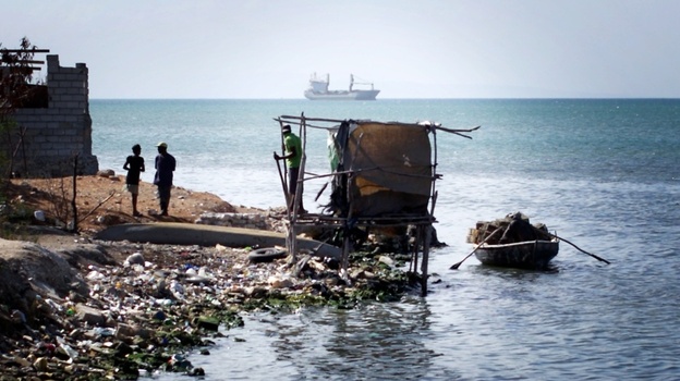 A makeshift latrine hangs over the water at the edge of Cite de Dieu, a slum in Port-au-Prince, Haiti. 