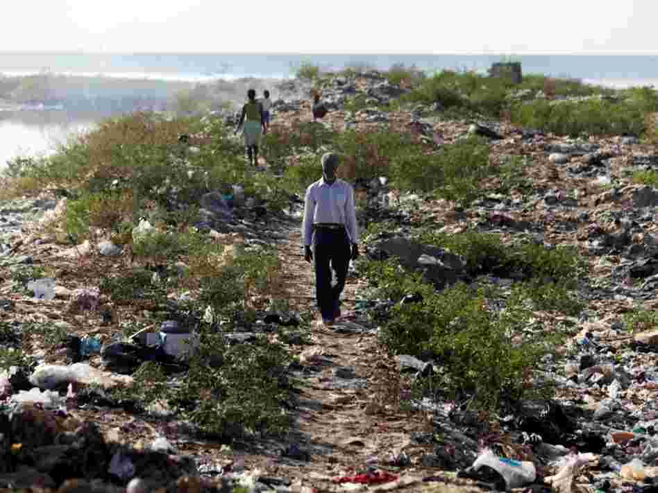 A man walks along the bank of one of Port-au-Prince's main sewage canals. This area is the de-facto bathroom for most of the residents of Cite de Dieu. A man walks along the bank of one of Port-au-Prince's main sewage canals. This area is the de-facto bathroom for most of the residents of Cite de Dieu.