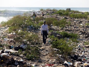 A man walks along the bank of one of Port-au-Prince's main sewage canals. This area is the de-facto bathroom for most of the residents of Cite de Dieu.