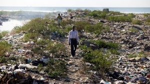 A man walks along the bank of one of Port-au-Prince's main sewage canals. This area is the de-facto bathroom for most of the residents of Cite de Dieu.