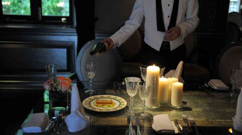 A waiter pours wine at a recreation of the Titanic's last meal at the Hullett House hotel in Hong Kong. A waiter pours wine at a recreation of the Titanic's last meal at the Hullett House hotel in Hong Kong.