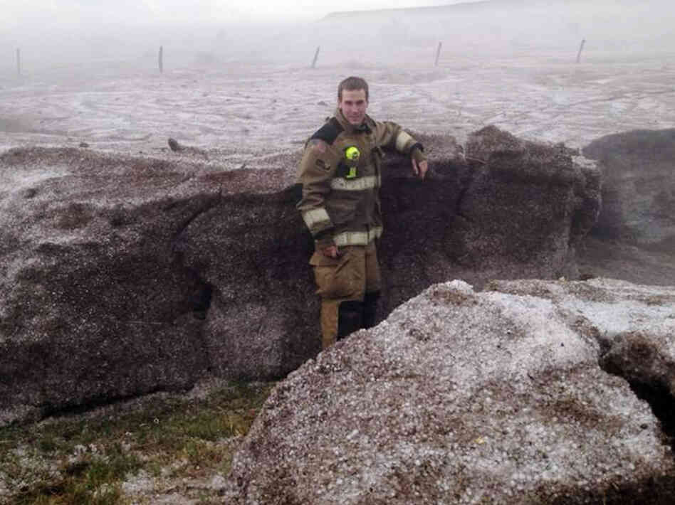 This photo provided by the Amarillo/Potter/Randall Office of Emergency Management shows Potter County firefighter Matt Dryden standing next to a wall of hail on Wednesday near Amarillo, Texas. The hail was pushed into drifts of up to 4-feet.