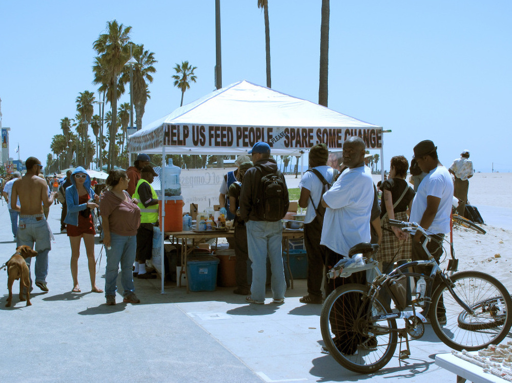 A food tent on Venice Beach, west of Los Angeles, offers a meal to homeless people and others in need. A new project in the area has the goal of reducing the area's homeless military veterans.