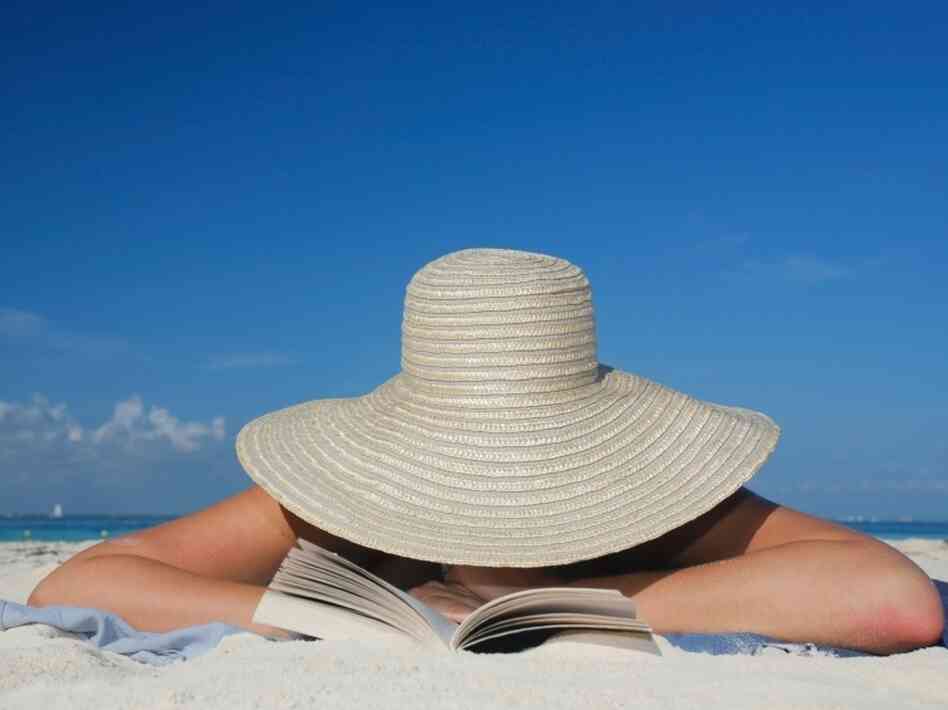 A woman reads on the beach. 