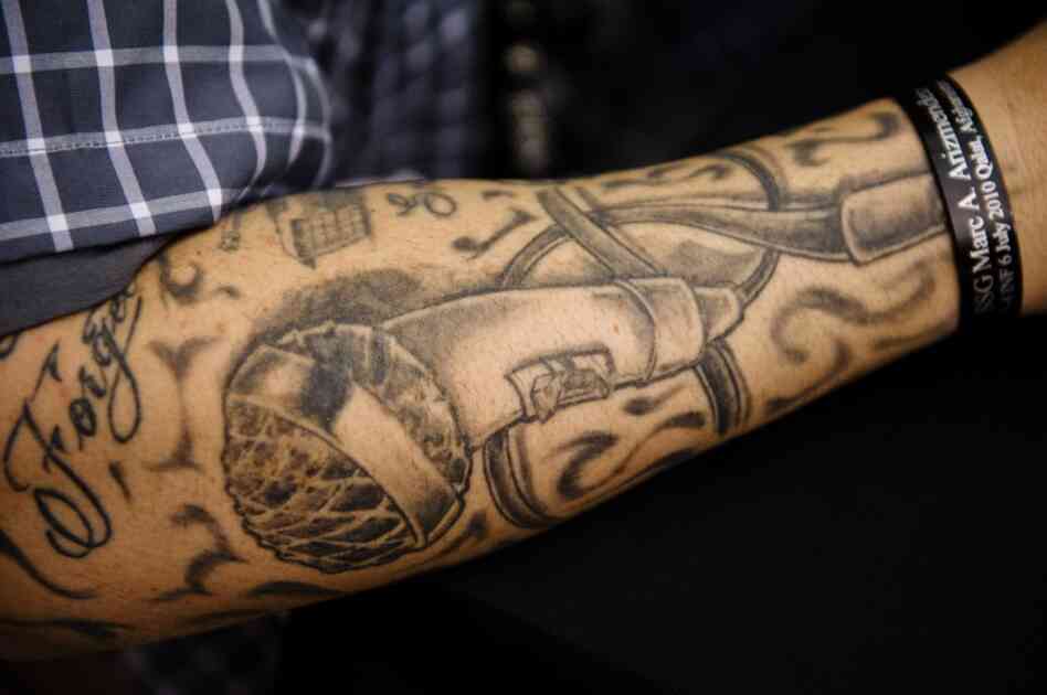 Barillaro's arm is tattooed with a microphone.