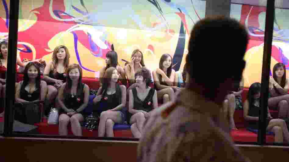 A man eyes some of the women working at the upscale Fish Tank brothel in Bangkok. The documentary Whores' Glory chronicles the experiences of sex workers in relatively clean establishments — and some living in de facto slavery. A man eyes some of the women working at the upscale Fish Tank brothel in Bangkok. The documentary Whores' Glory chronicles the experiences of sex workers in relatively clean establishments — and some living in de facto slavery.