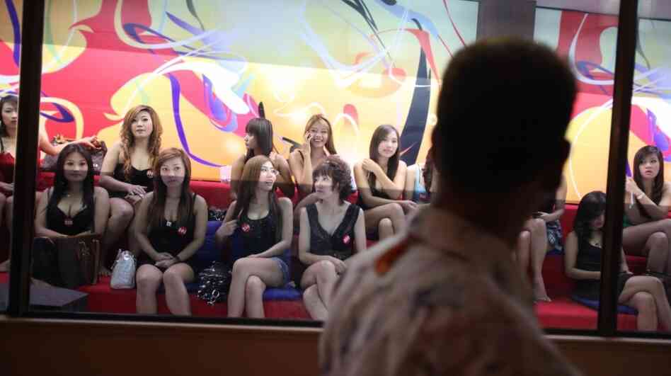 A man eyes some of the women working at the upscale Fish Tank brothel in Bangkok. The documentary Whores' Glory chronicles the experiences of sex workers in relatively clean establishments — and some living in de facto slavery. A man eyes some of the women working at the upscale Fish Tank brothel in Bangkok. The documentary Whores' Glory chronicles the experiences of sex workers in relatively clean establishments — and some living in de facto slavery.